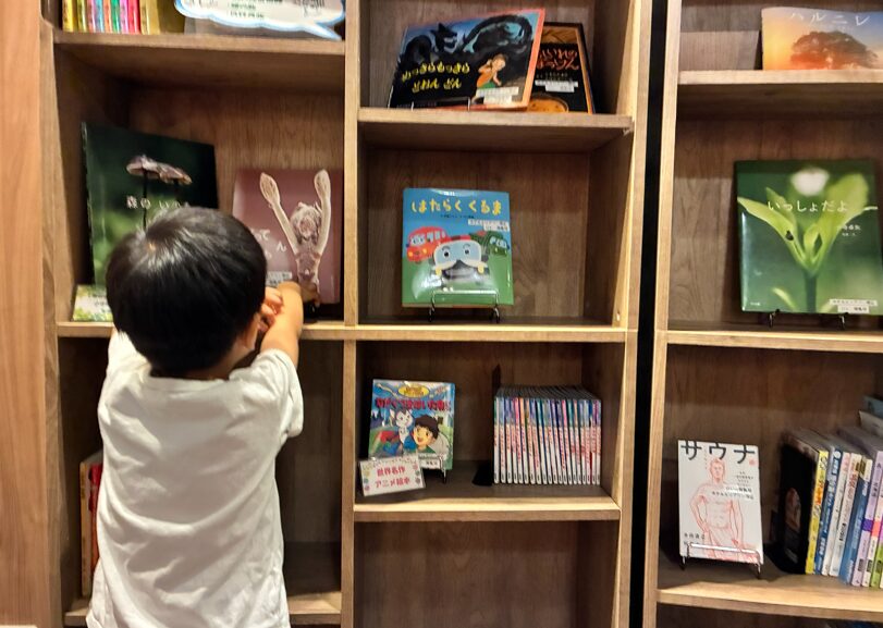 ホテルエリアワン帯広のロビーで絵本を選ぶ4歳の子ども